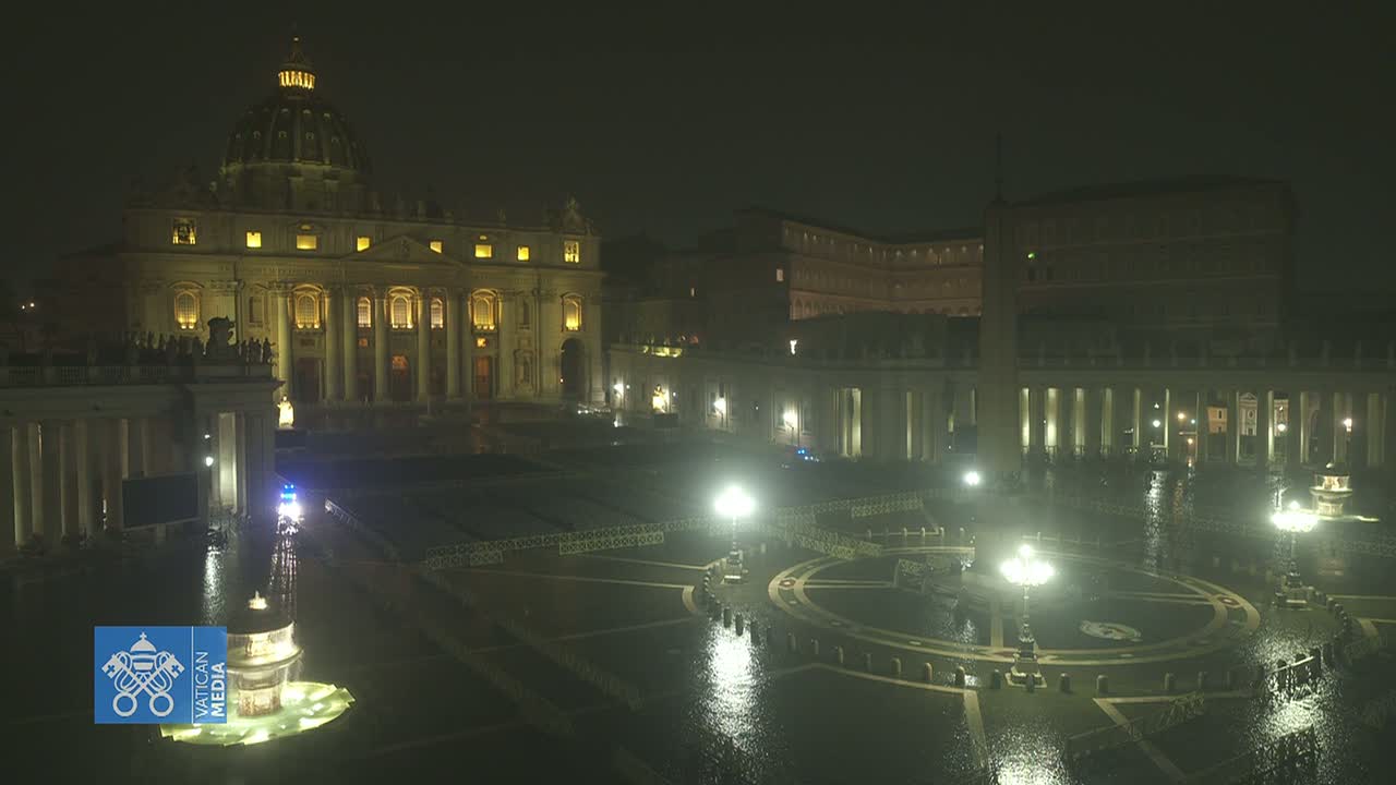 St. Peter's Basilica and St. Peter's Square are illuminated at night in the rain.