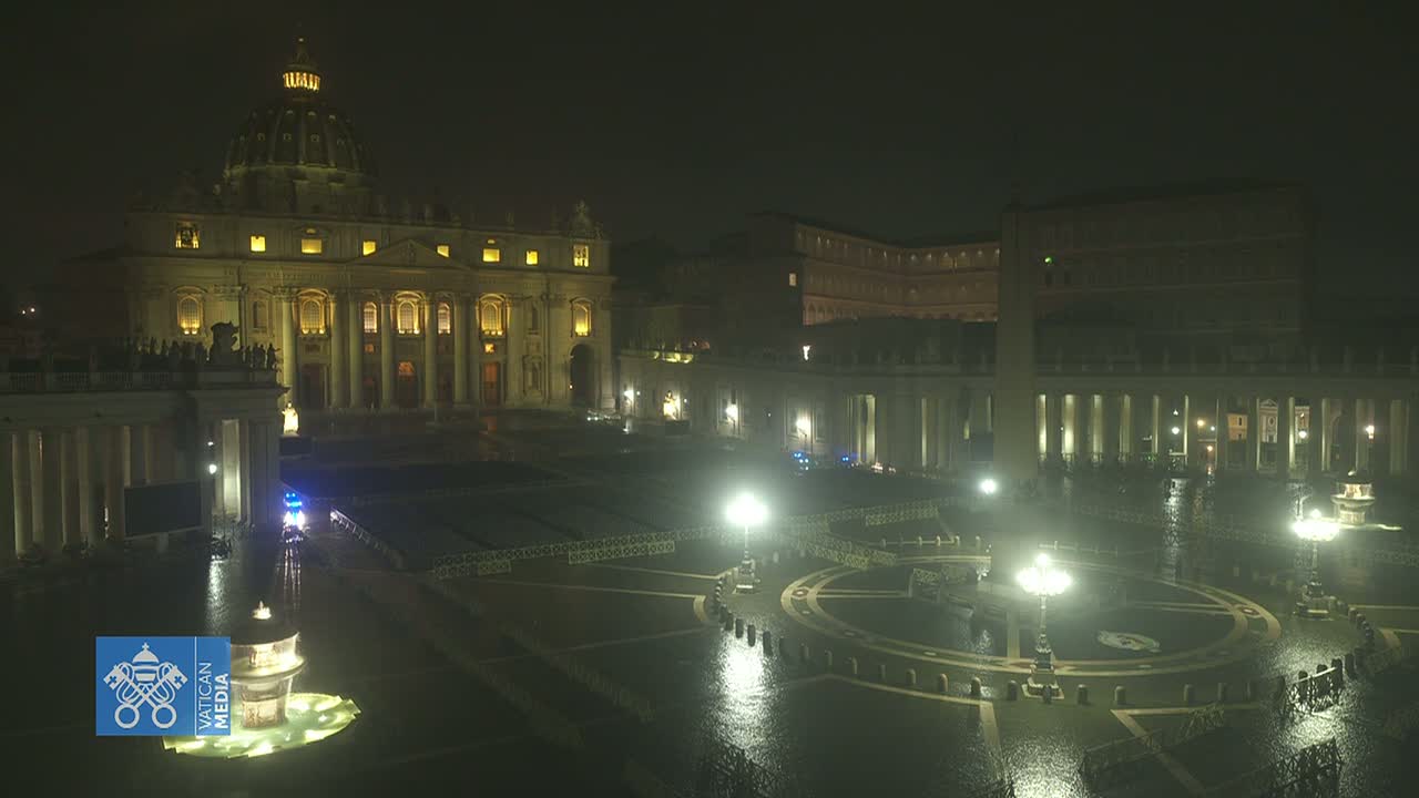 St. Peter's Basilica and St. Peter's Square at night in the rain, illuminated by numerous lights.