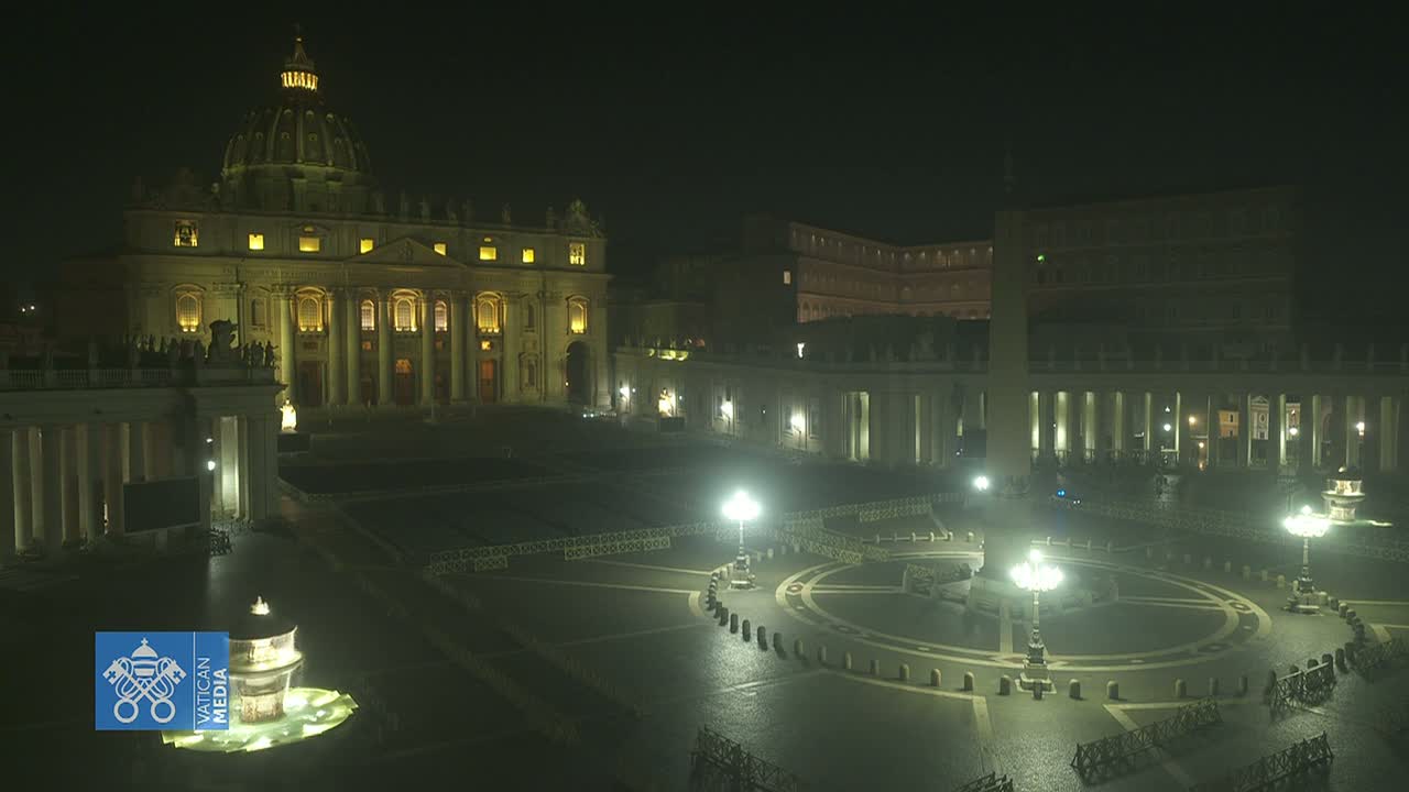 St. Peter's Basilica and St. Peter's Square are illuminated at night under a dark sky.