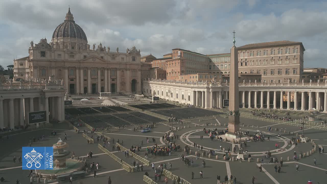 St. Peter's Basilica and St. Peter's Square in Vatican City are shown on an overcast day with many people sparsely spread throughout the square.