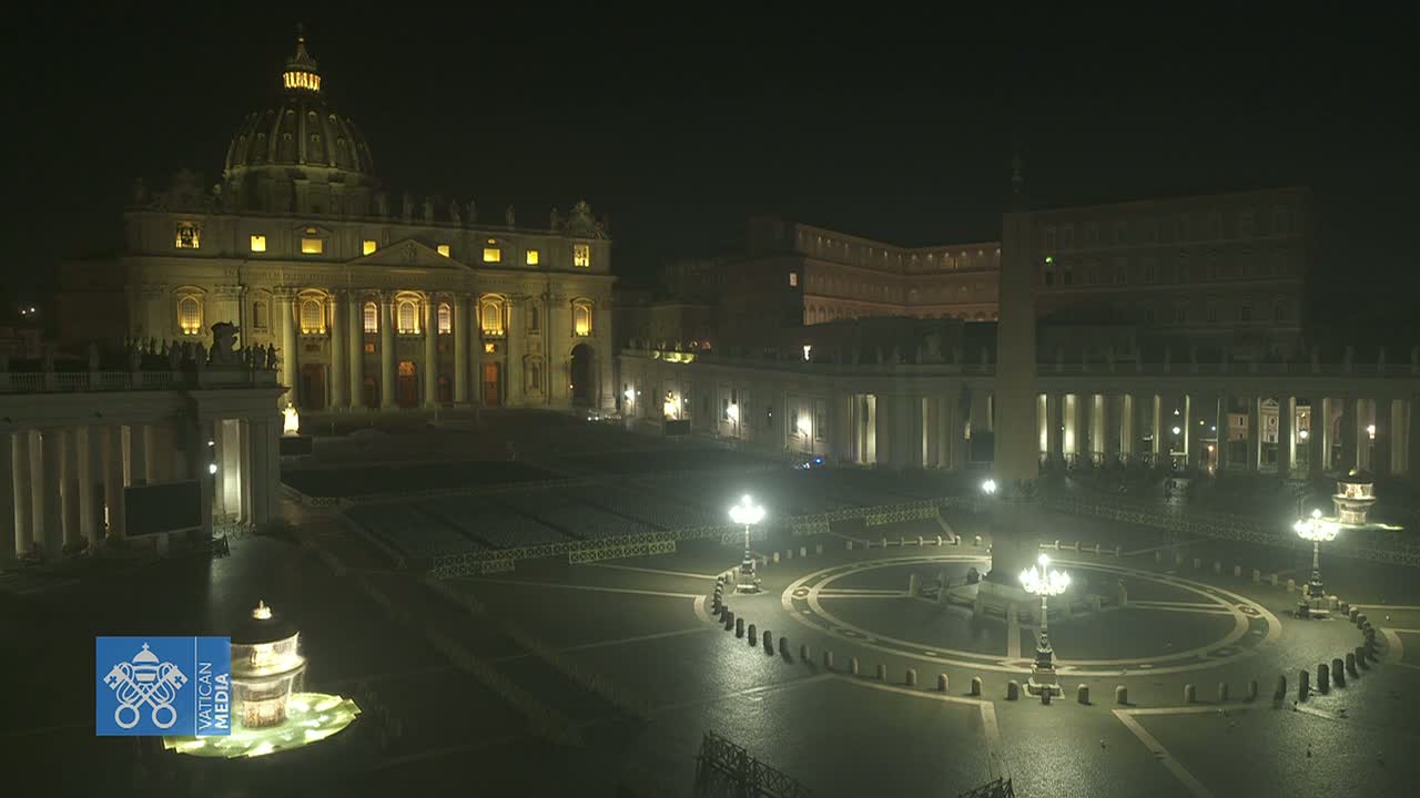 St. Peter's Basilica and Square at night, illuminated, with a mostly empty plaza and wet ground.