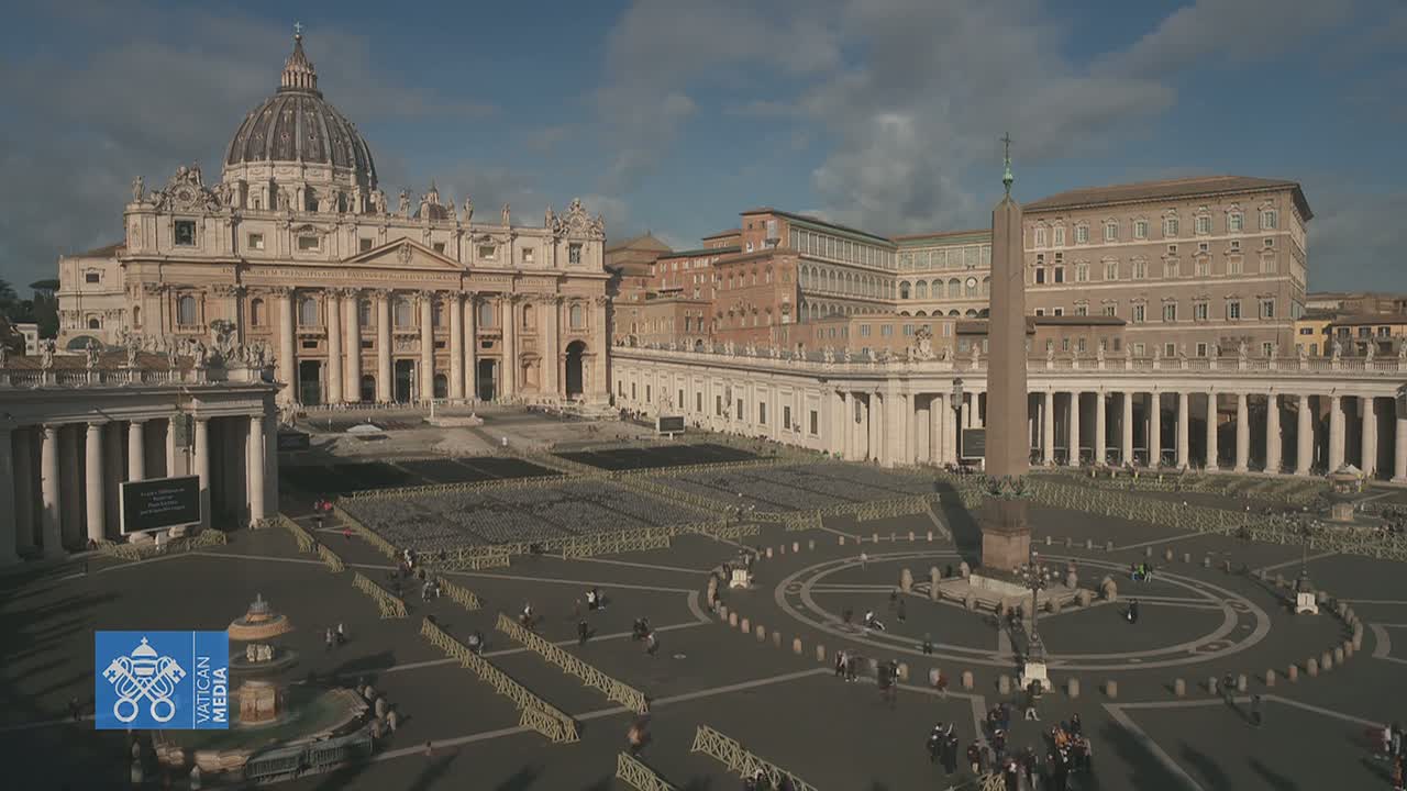 St. Peter's Basilica and St. Peter's Square in Vatican City are shown on a partly sunny day, with the square largely empty except for a few people and some barriers.