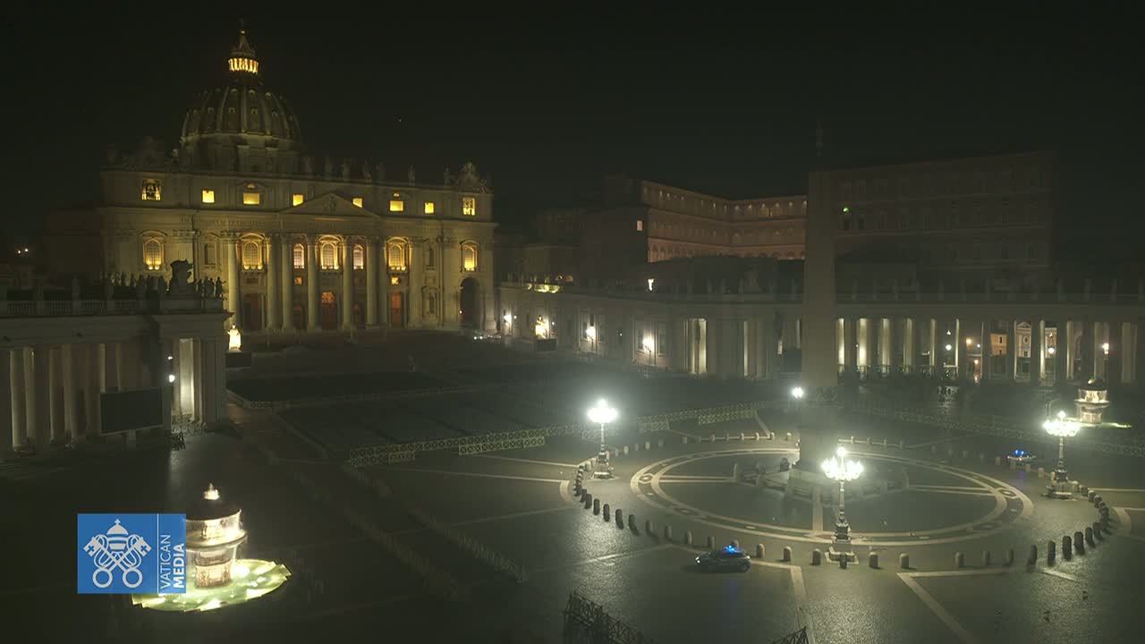 St. Peter's Basilica and its square are illuminated at night, with a mostly empty plaza and a fountain visible.