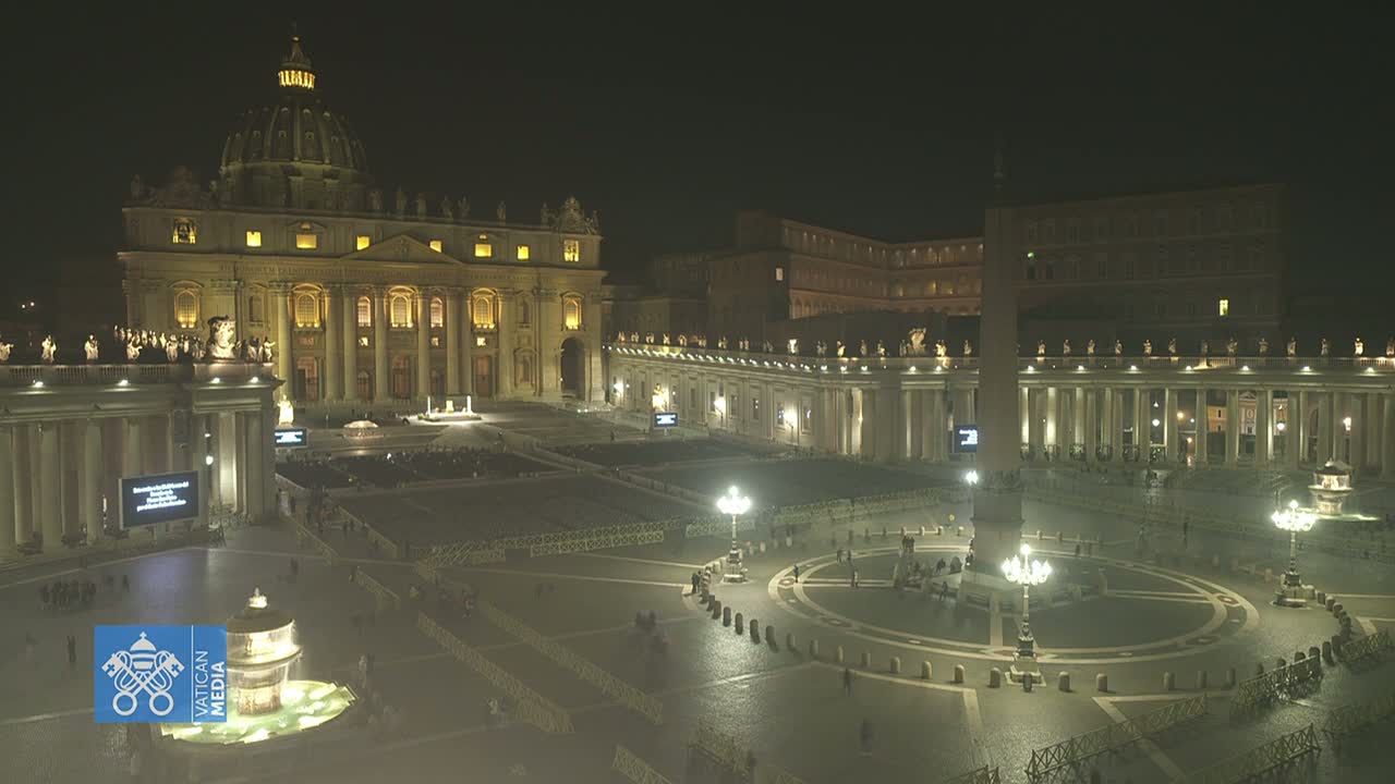 St. Peter's Square and Basilica at night, illuminated, with a mostly empty plaza and a clear sky.