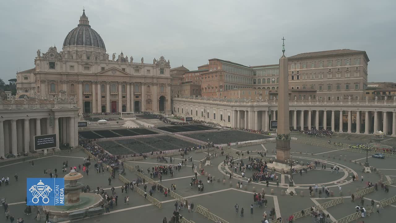 A large crowd gathers in St. Peter's Square in front of St. Peter's Basilica under an overcast sky.