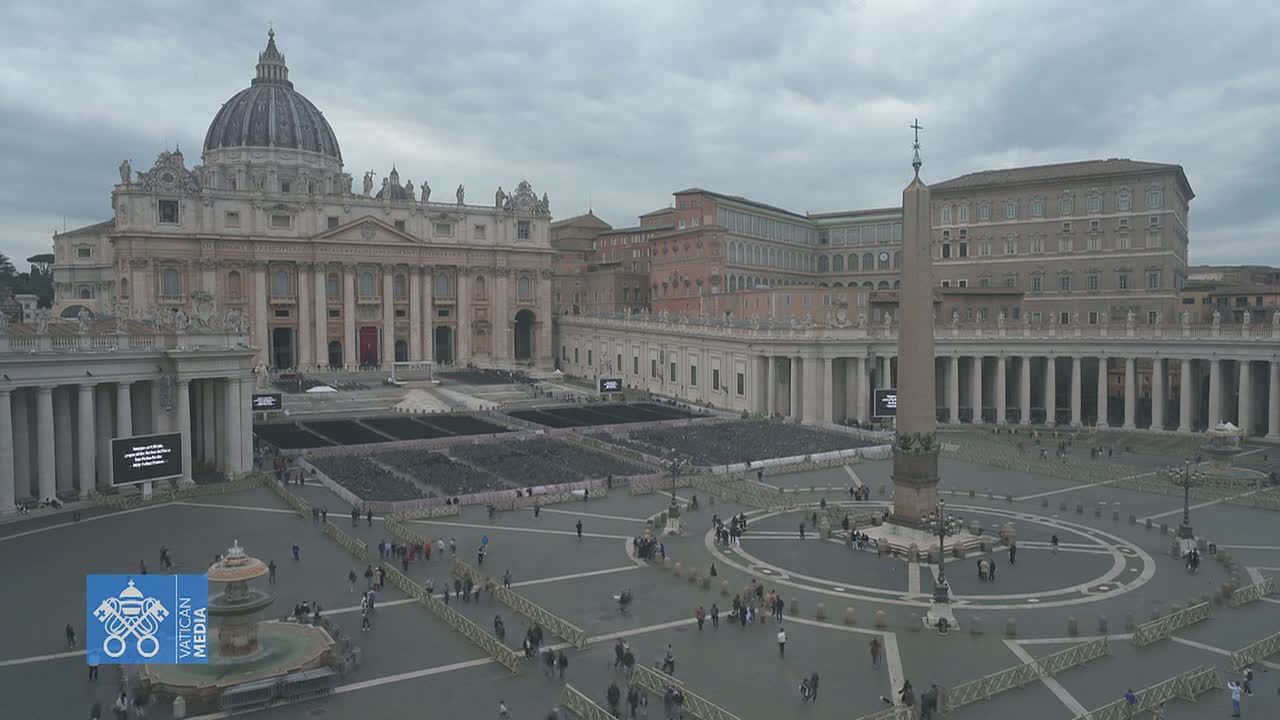 St. Peter's Basilica and Square in Vatican City on an overcast day, with many people sparsely scattered across the large plaza.