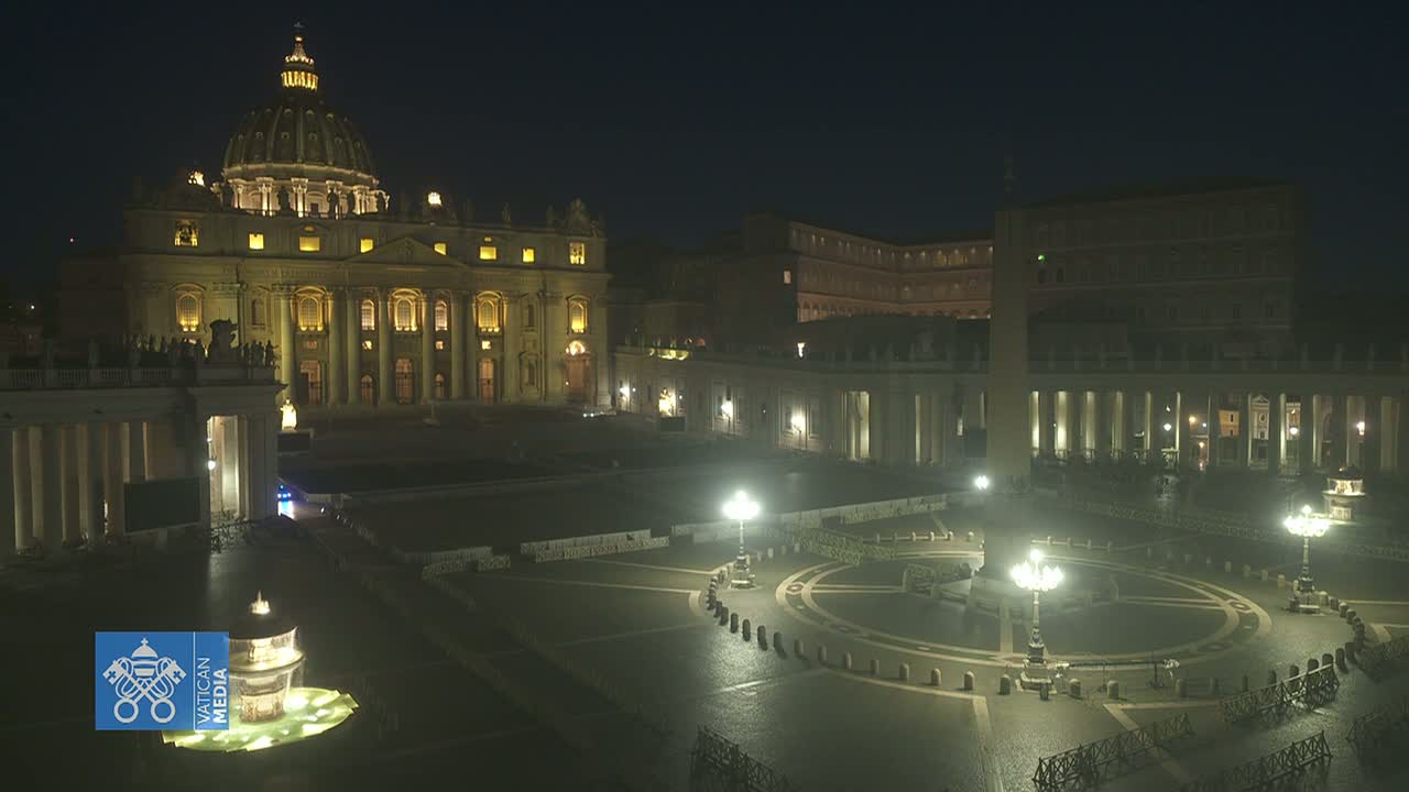 St. Peter's Basilica and St. Peter's Square are illuminated at night, showing a mostly empty plaza.