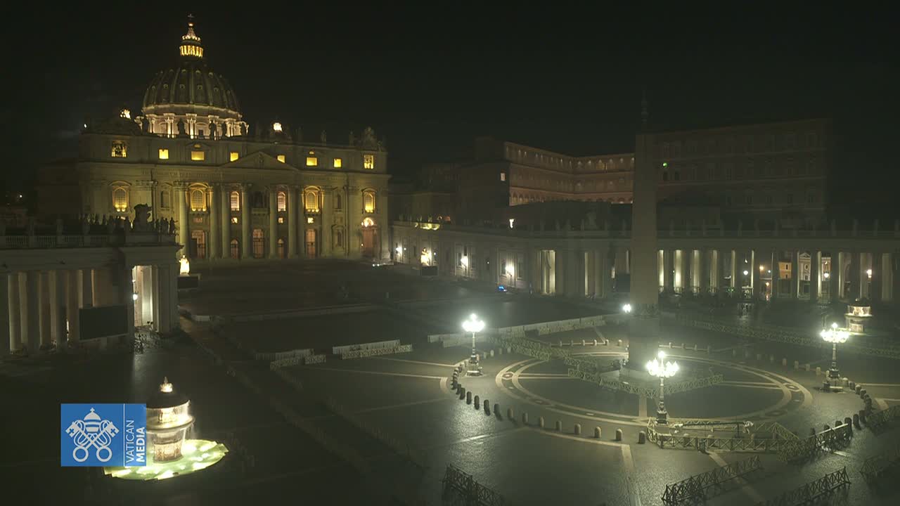 St. Peter's Basilica and Square are illuminated at night, with a fountain in the foreground and few people visible.