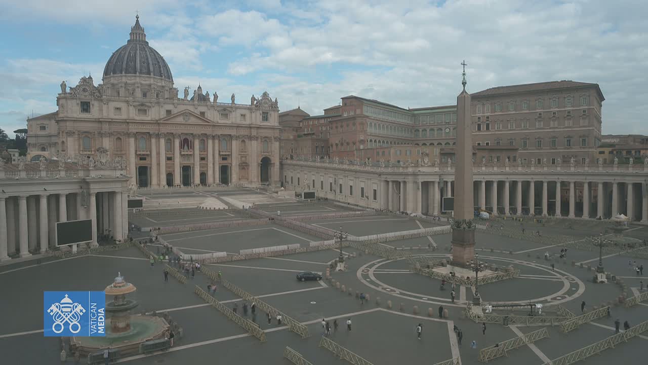 St. Peter's Basilica and Square in Vatican City, under a cloudy sky, are largely empty except for a few scattered people and barriers.