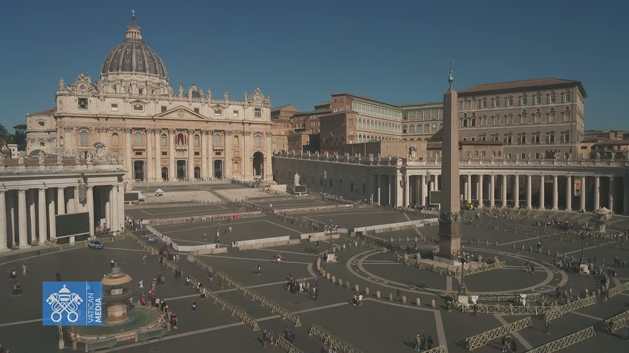 St. Peter's Basilica and St. Peter's Square in Vatican City are shown on a sunny day, with a few people scattered throughout the large plaza.