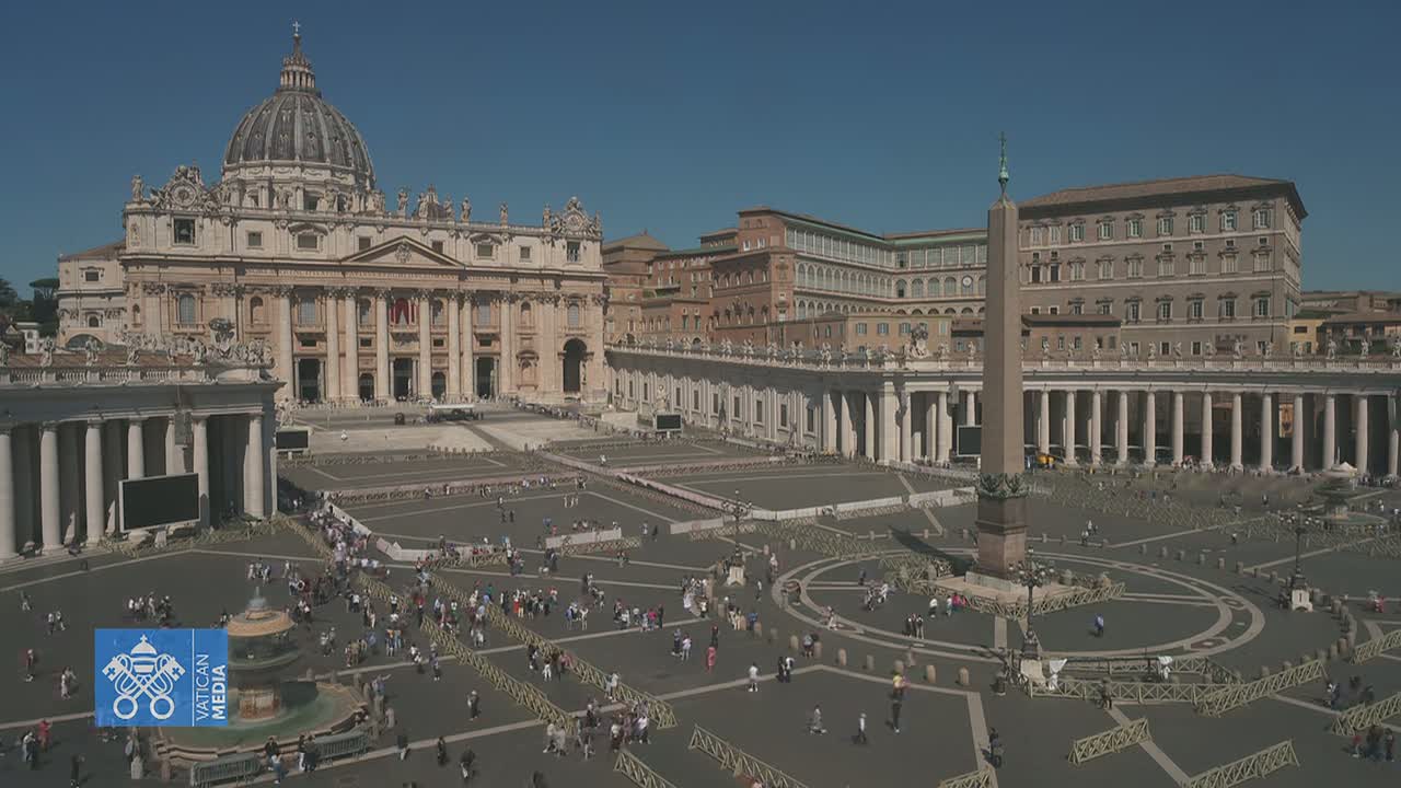 St. Peter's Basilica and Square in Vatican City are shown on a sunny day, with numerous people sparsely scattered across the large plaza.