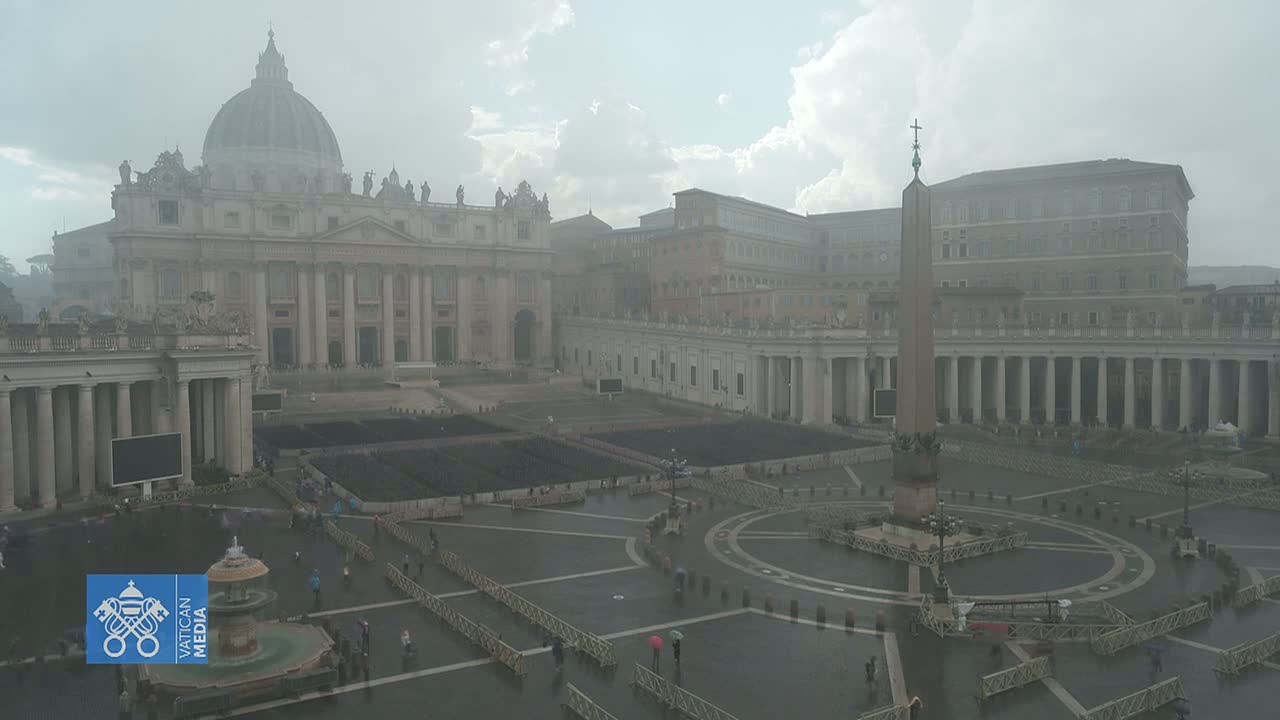 St. Peter's Basilica and St. Peter's Square are shown on a rainy day, with many rows of chairs set up in the square.