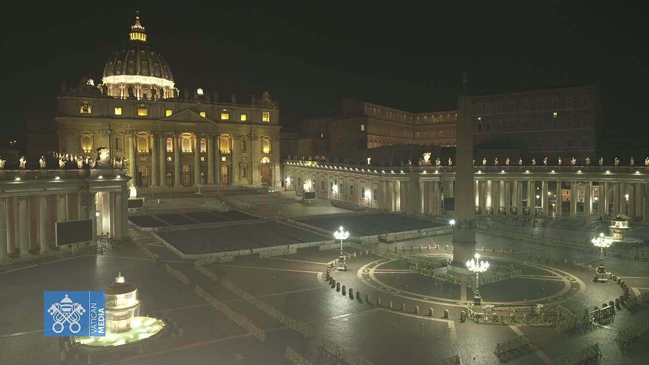 St. Peter's Basilica and Square are illuminated at night, appearing empty and wet.