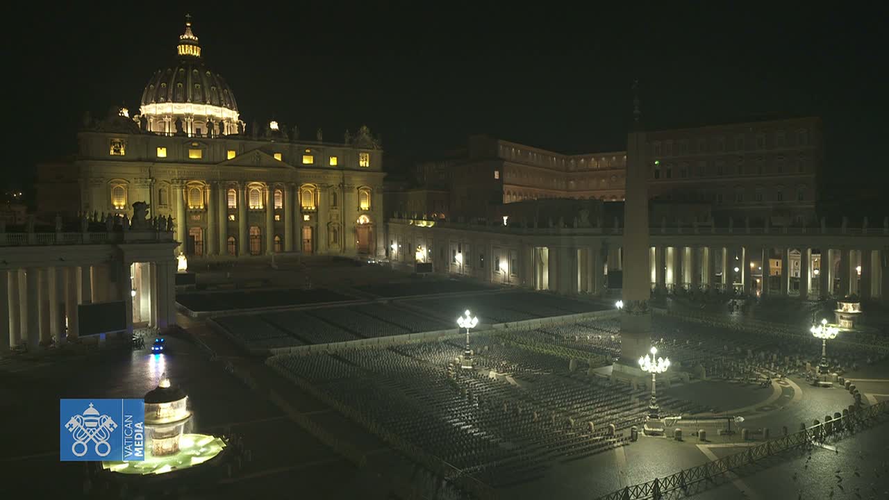 At night, St. Peter's Basilica and Square are illuminated, with rows of chairs set up in the square.