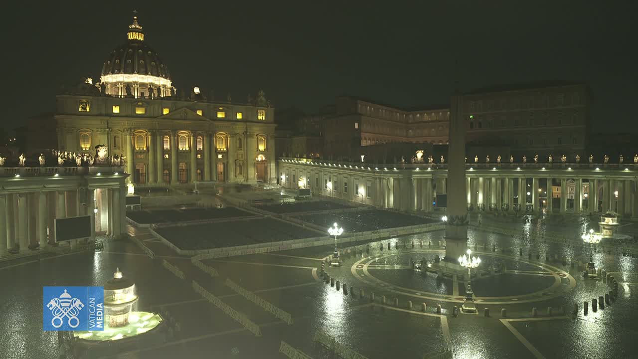 St. Peter's Basilica and Square at night in the rain, illuminated by lights.