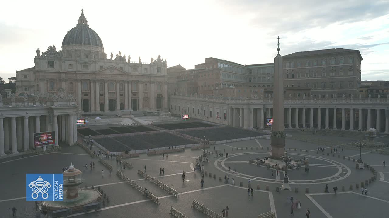 A hazy view of St. Peter's Square in Vatican City, showing St. Peter's Basilica and a sparsely populated plaza.