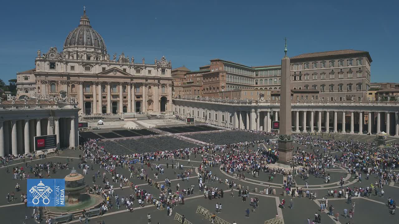 A large crowd gathers in St. Peter's Square in front of St. Peter's Basilica on a sunny day.