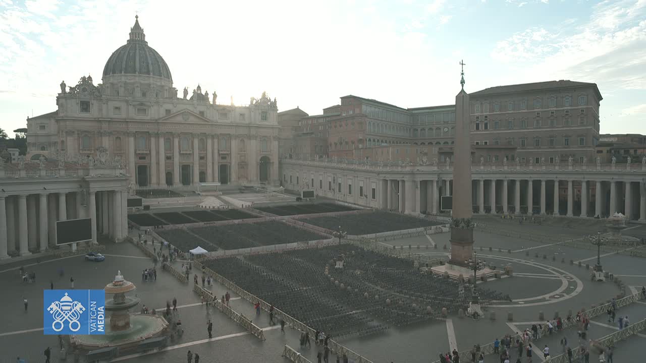 St. Peter's Basilica and St. Peter's Square in Vatican City are shown on an overcast day, with numerous empty chairs set up in the square.