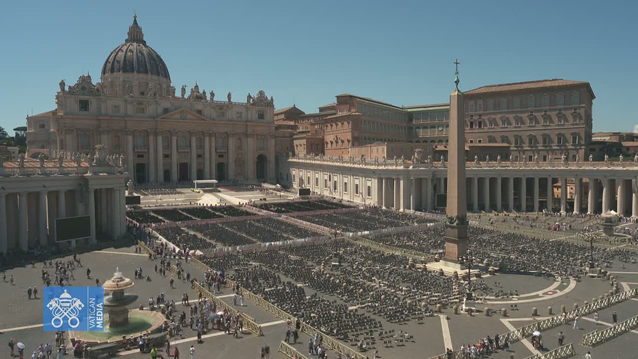 A large crowd gathers in St. Peter's Square in front of St. Peter's Basilica on a sunny day.