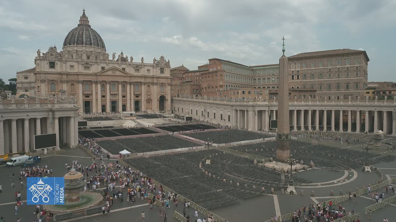 A large crowd gathers in St. Peter's Square in front of St. Peter's Basilica under an overcast sky.