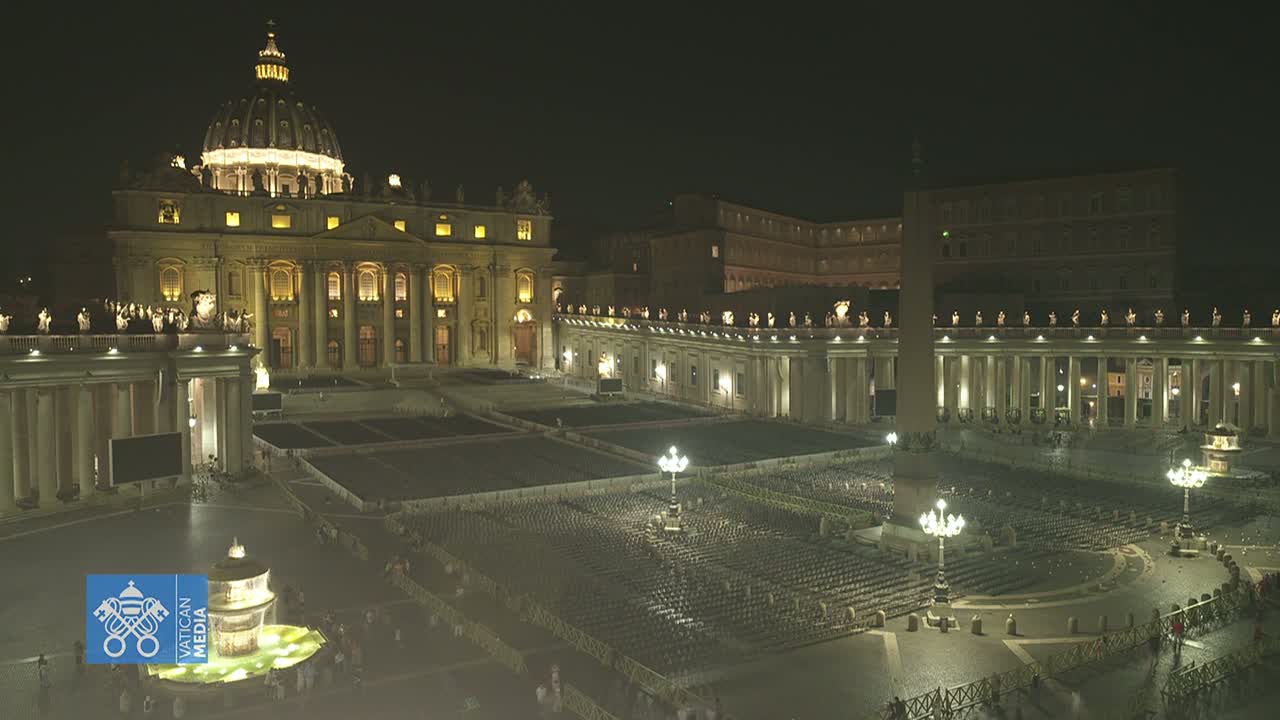 St. Peter's Basilica and Square in Vatican City are filled with many empty chairs, under a hazy, sunny sky.