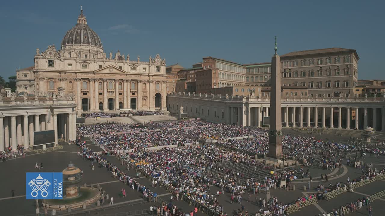 A large crowd gathers in St. Peter's Square in front of St. Peter's Basilica on a sunny day.