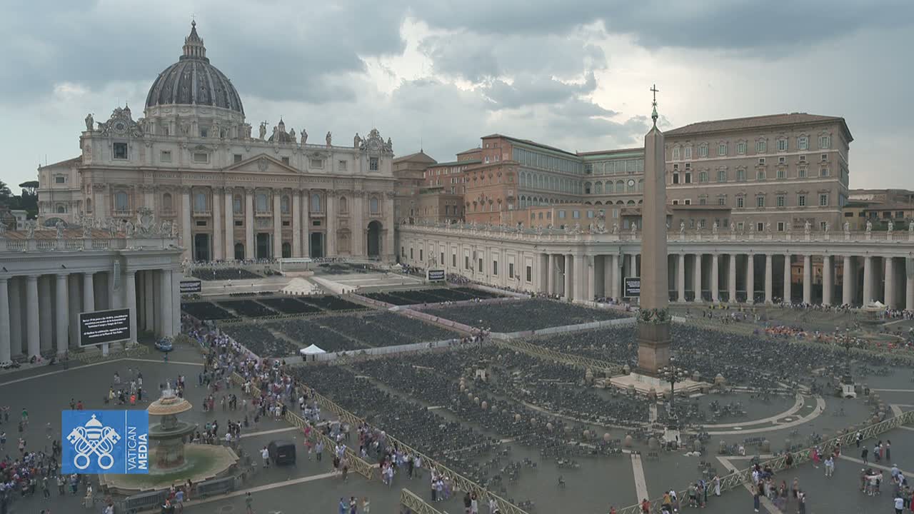St. Peter's Square in Vatican City, under a cloudy sky, is filled with many empty chairs and a scattering of people.