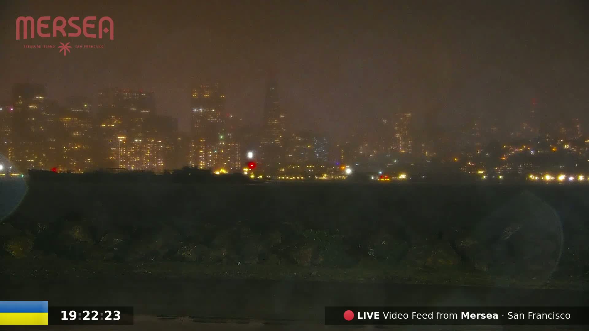 A nighttime view of a city skyline shrouded in fog or mist.
