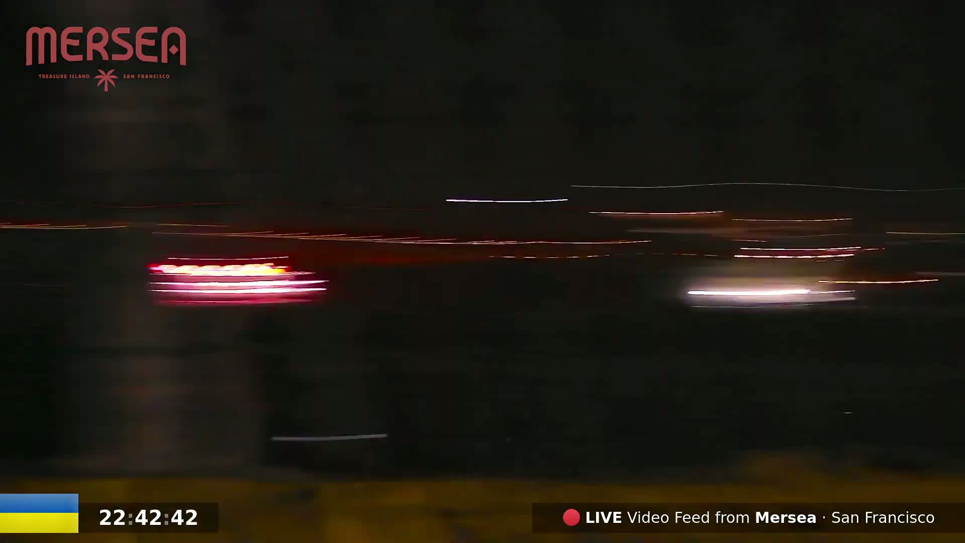 Streaks of red, white, and orange light from moving vehicles are visible against a dark nighttime sky.