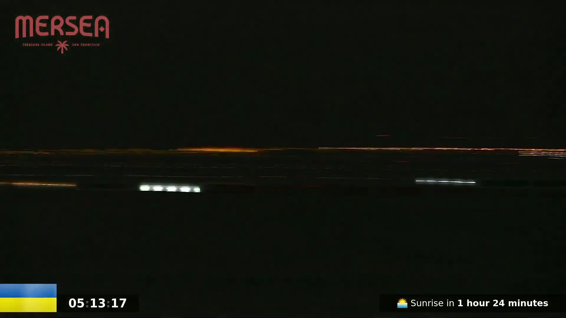 A nighttime, long-range view shows a horizon line of faint, distant lights and a few closer, brighter lights.