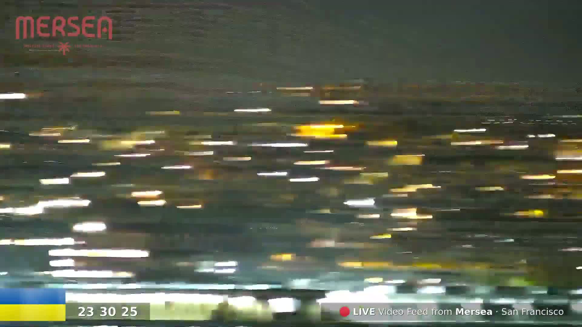 A blurry nighttime image shows streaks of light, likely from moving vehicles, against a dark background.