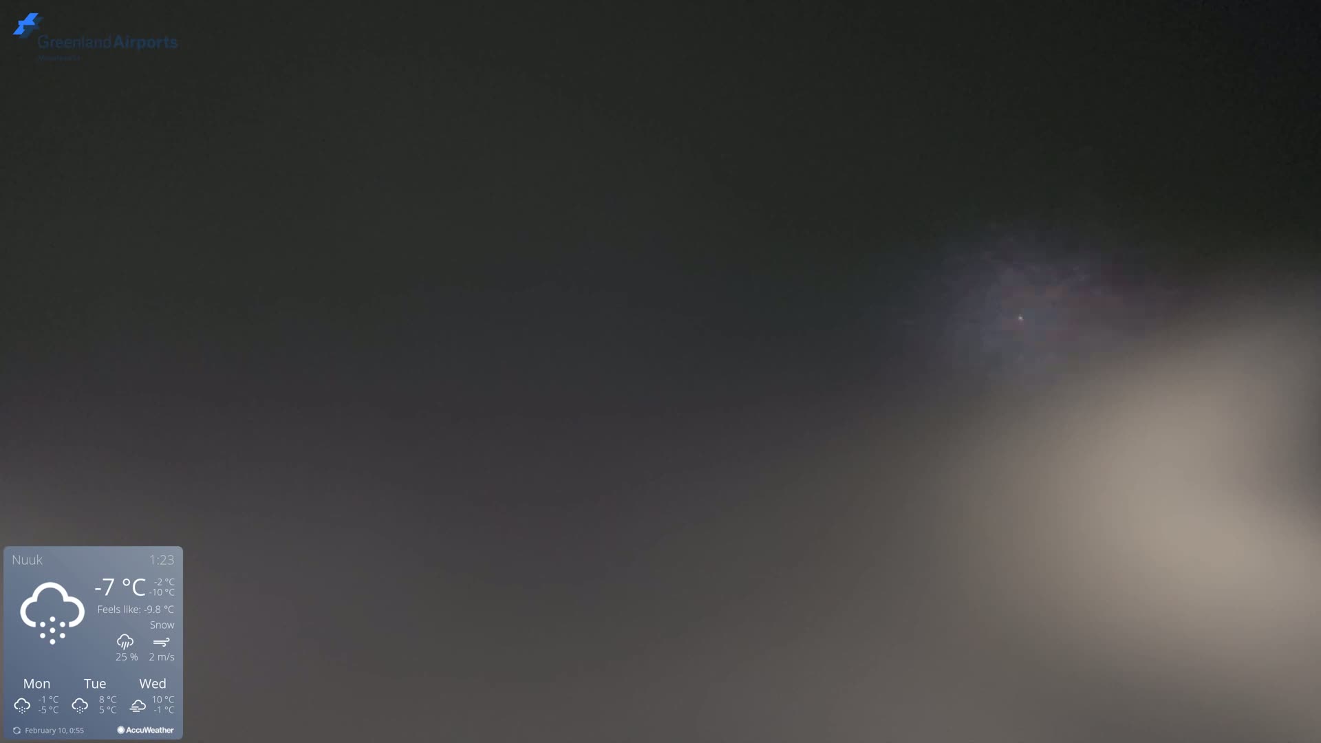 A blurry, dark gray image shows a snowy, overcast sky with a faint light source in the upper right.