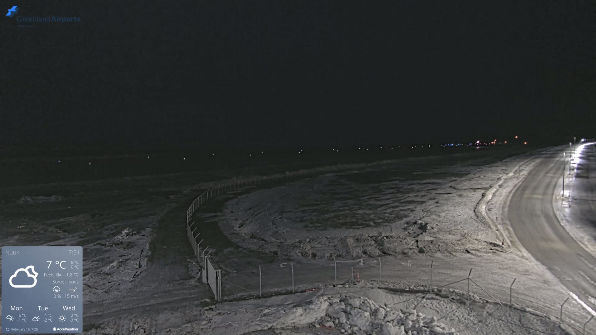 A snow-covered airfield at night with some clouds and a 7°C temperature, illuminated by several distant lights.