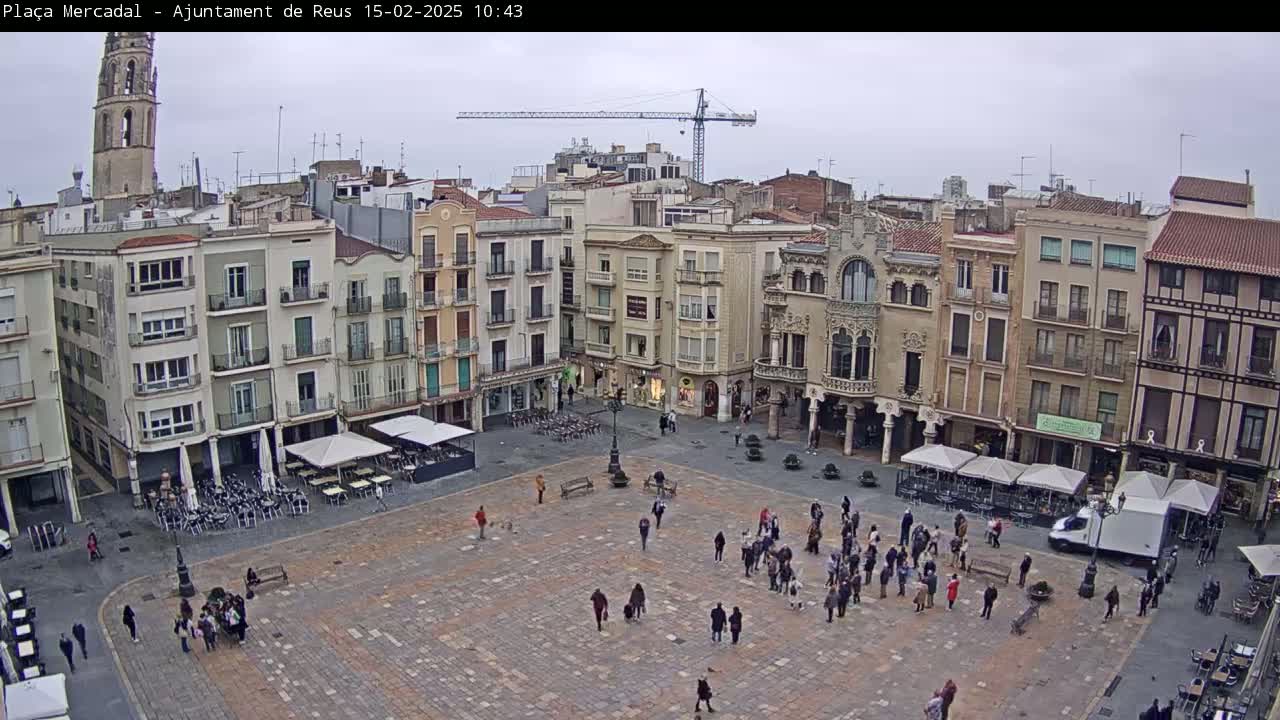 A large town square with several multi-story buildings surrounding it, under an overcast sky.