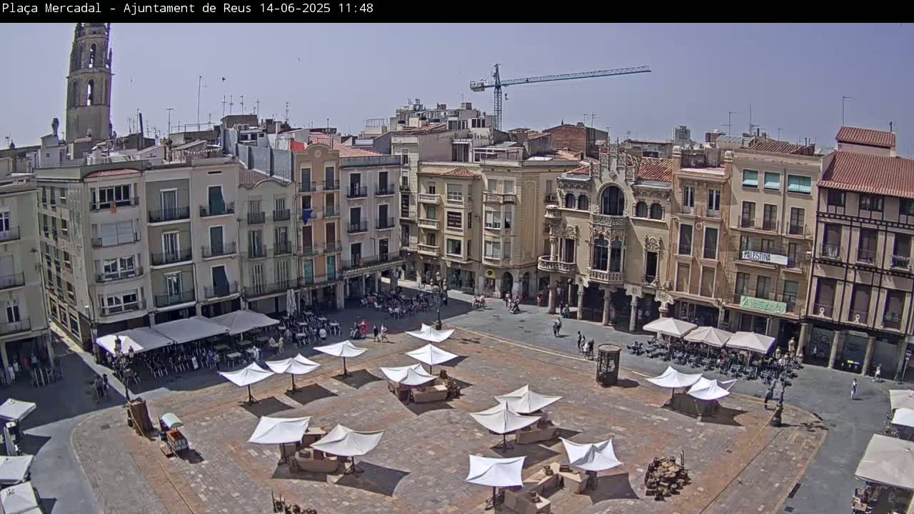 A sunny day reveals a large town square filled with white umbrellas shading outdoor seating areas, surrounded by multi-story buildings under a clear sky.