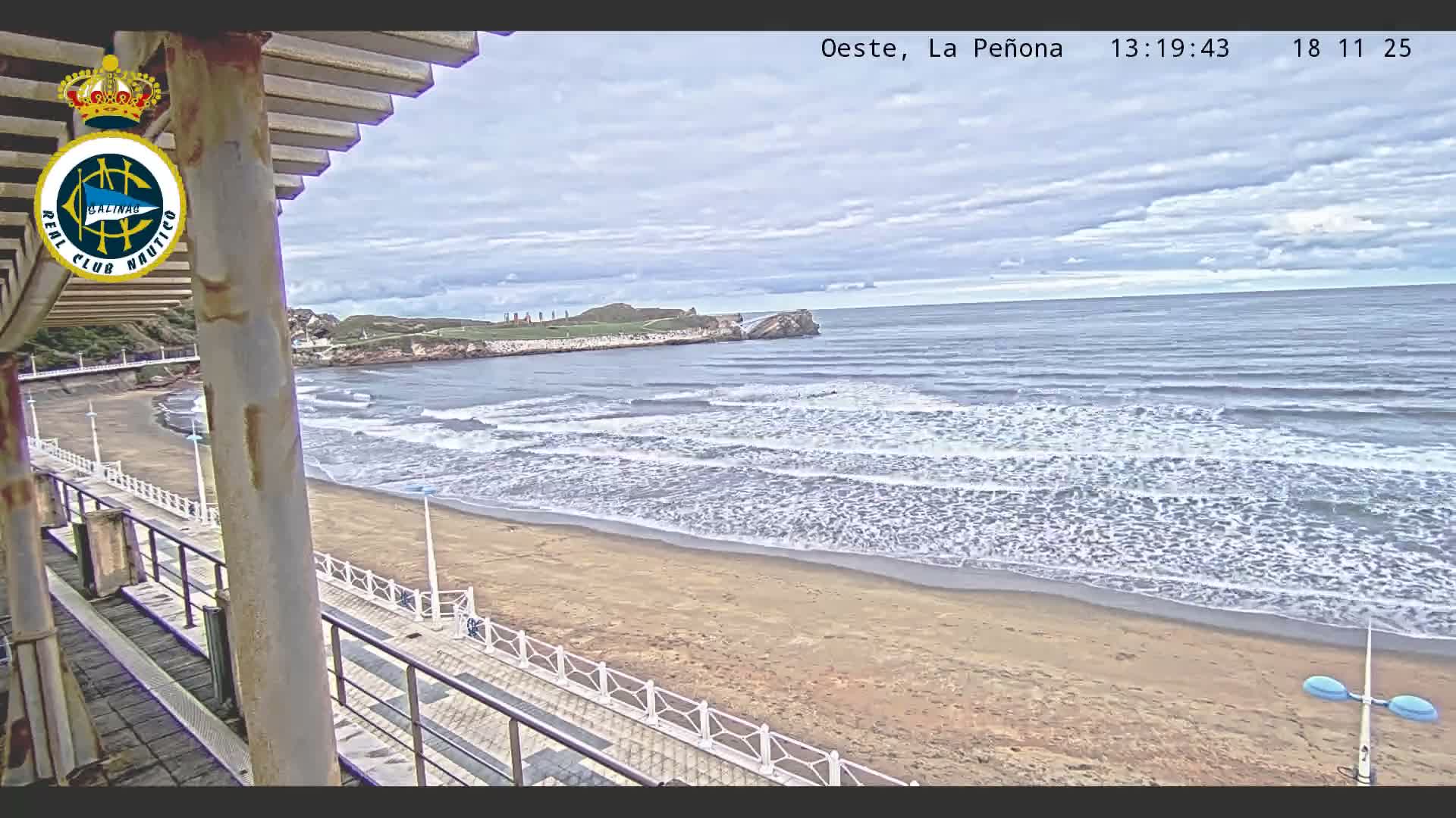 A series of brightly illuminated piers and boardwalks line a dark beach with gentle waves under a clear night sky.