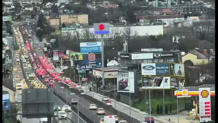 A long line of slow-moving traffic on a highway under overcast skies.
