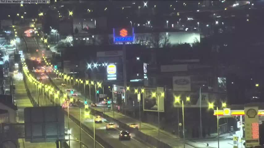 A nighttime aerial view of a highway with moderate traffic, lined with illuminated star-shaped streetlights.