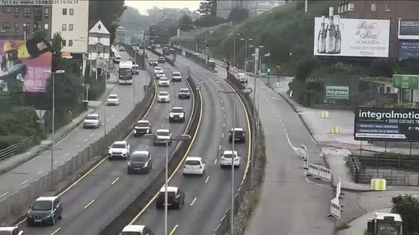 A multi-lane highway with moderate traffic flows under an overcast sky.