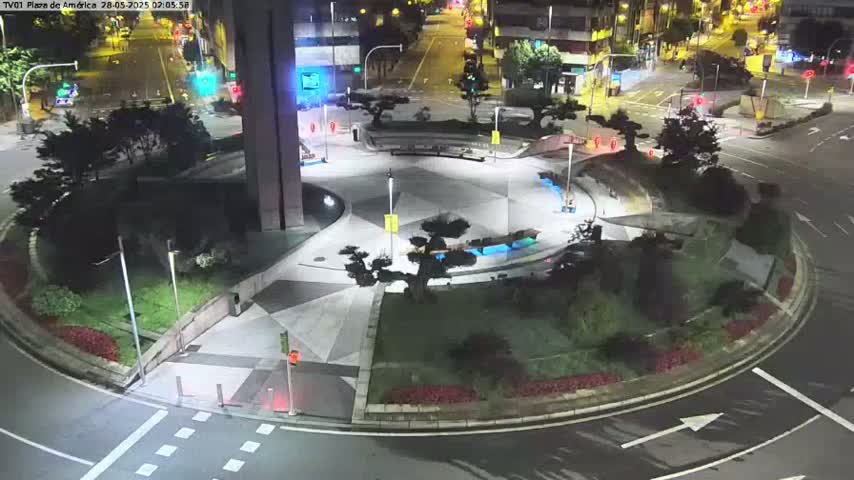 A nighttime aerial view of a circular plaza with landscaping, lighting, and a roadway surrounding it.