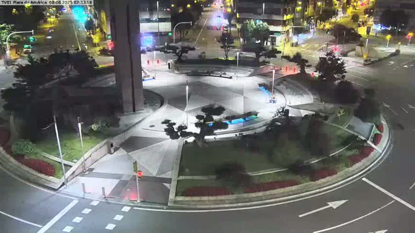 A nighttime aerial view of a circular plaza with landscaping and a roadway surrounding it.