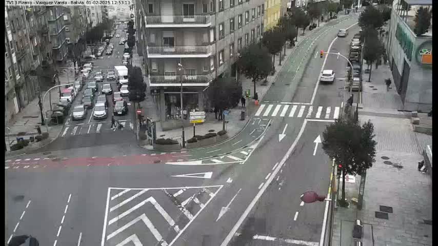 A city intersection with moderate traffic, bike lanes, and overcast weather.