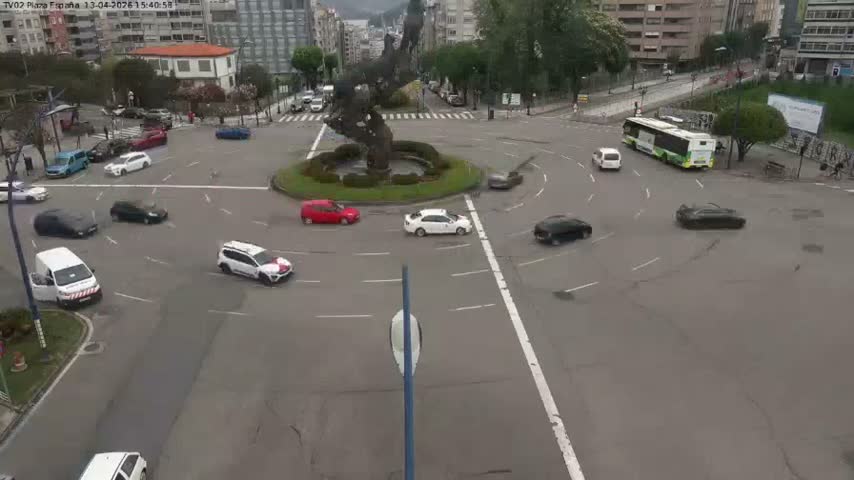 A busy urban intersection is depicted at night with vehicles on the roads, pedestrians crossing and waiting, and streetlights illuminating the scene under clear weather.