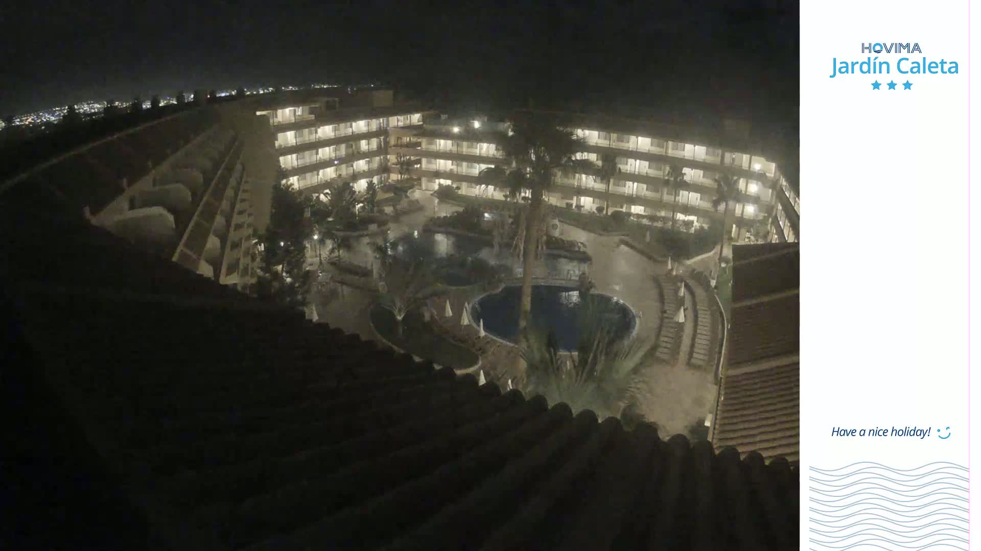 A nighttime aerial view shows a multi-story hotel complex with pools and landscaping.