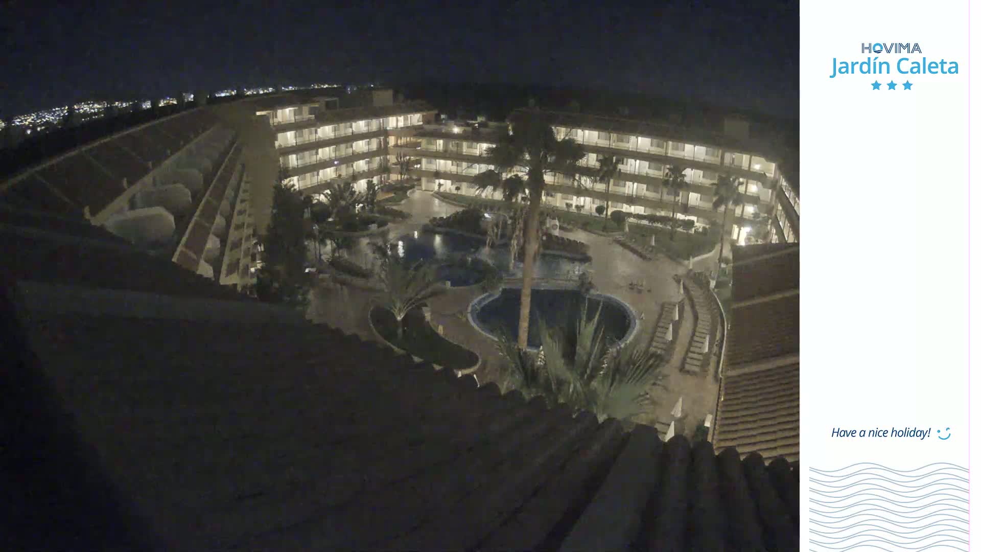 A nighttime overhead view of a multi-story hotel complex with surrounding pools and landscaping.