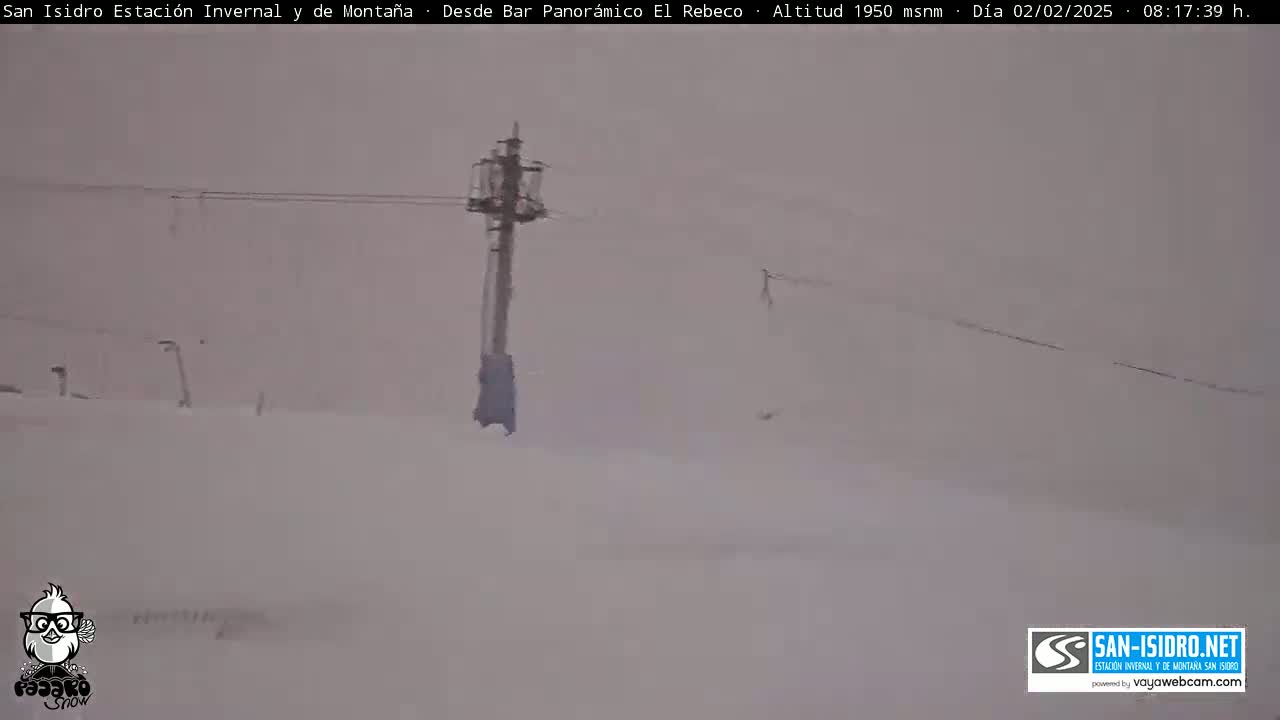 A snow-covered landscape is visible, featuring a tall structure with wires, under hazy weather conditions.