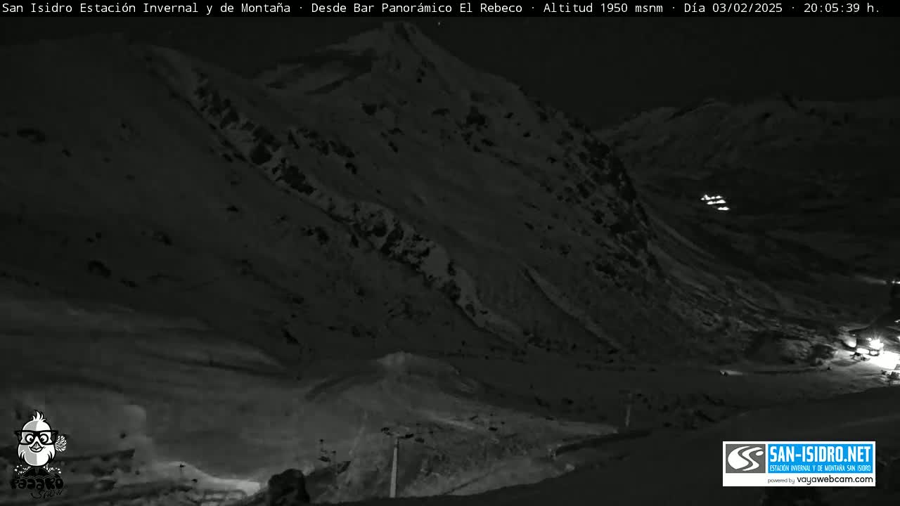 A nighttime, snow-covered mountain slope is shown under dark skies.