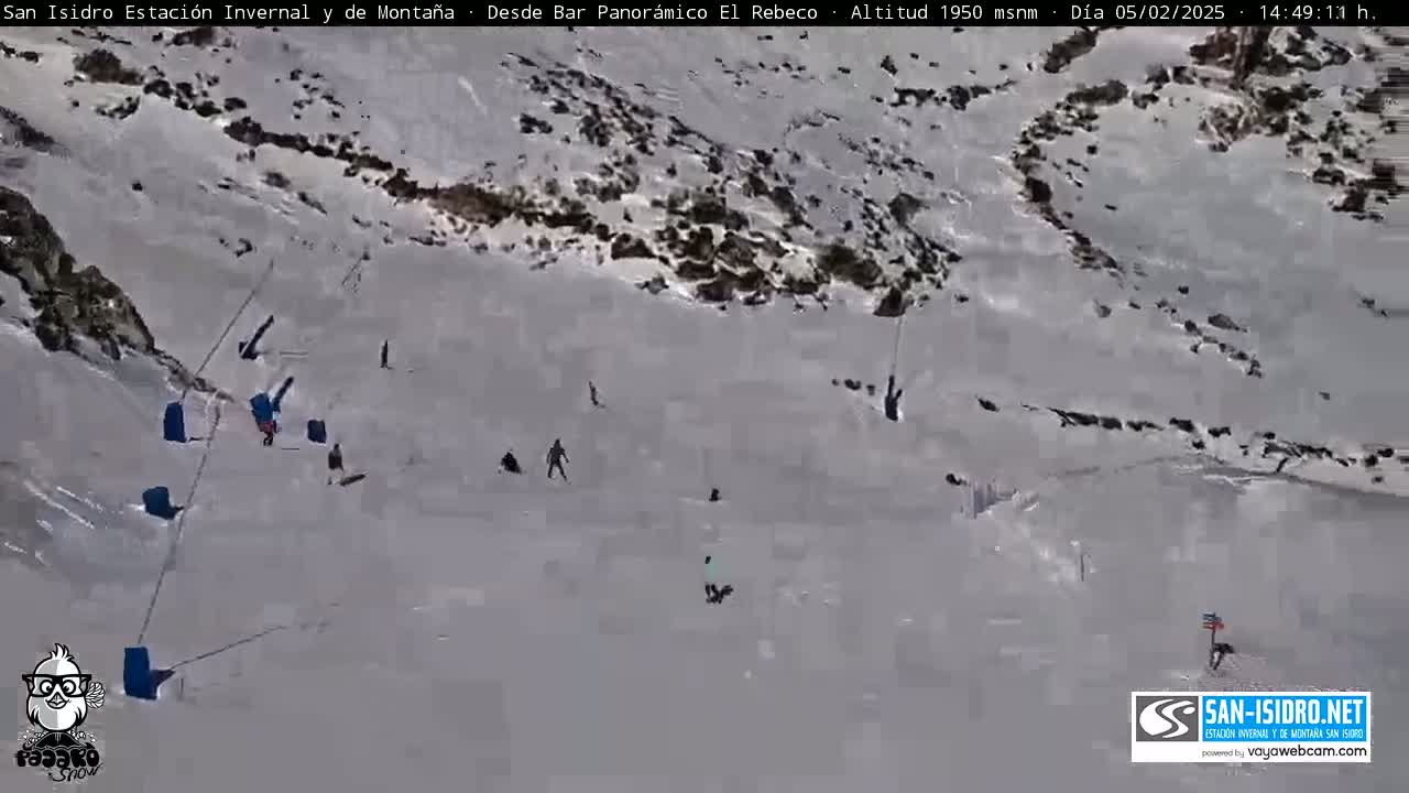 A snow-covered slope with several skiers and snowboarders on it.