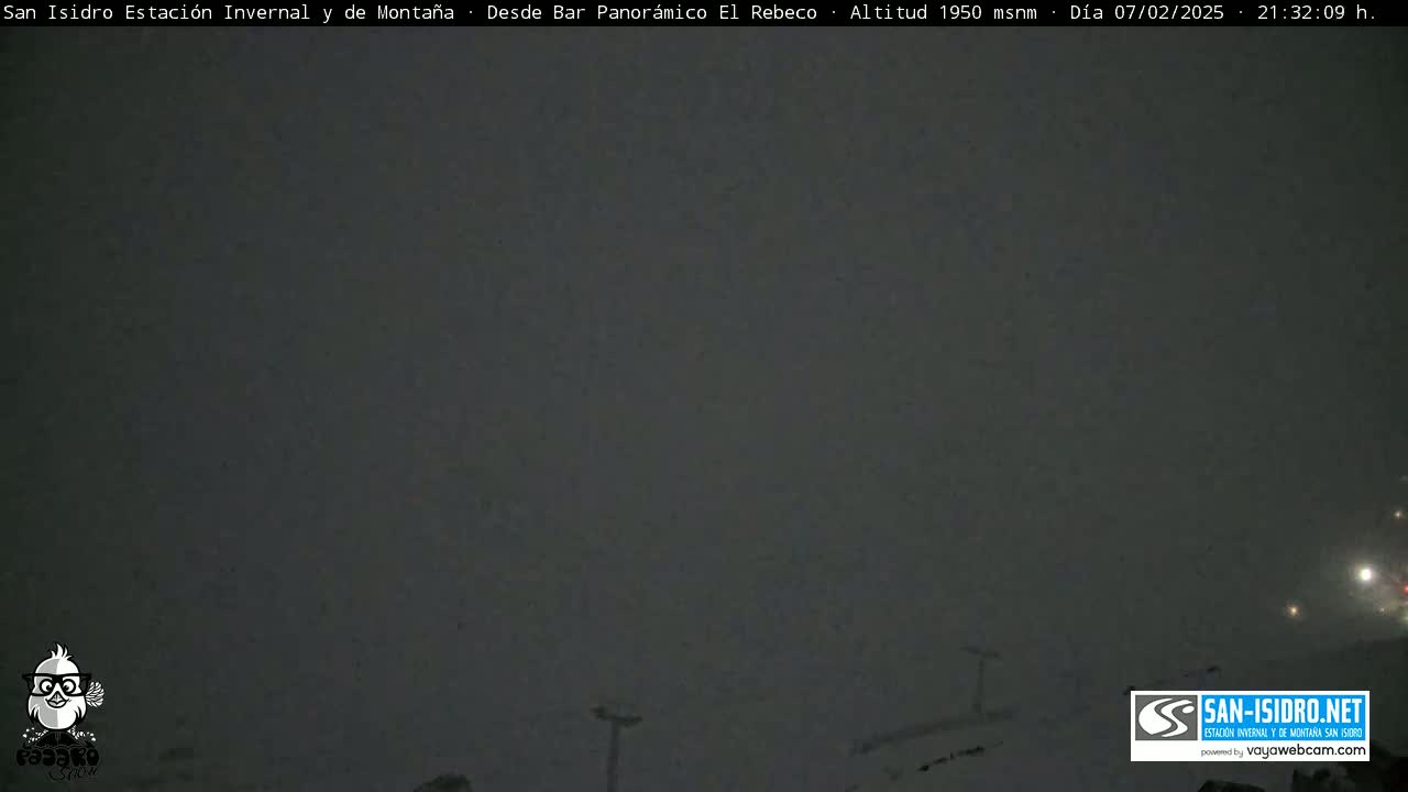 A nighttime scene of heavy snowfall obscures the view of a ski slope.