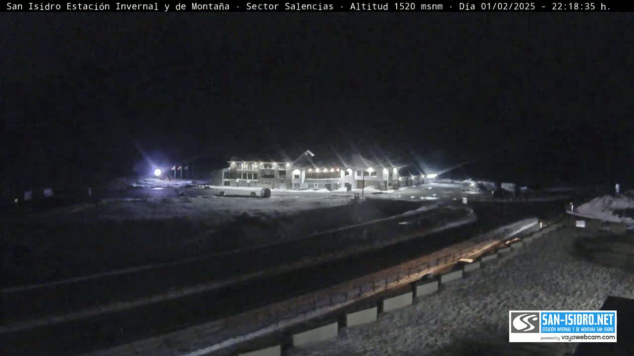 A snow-covered mountain resort is illuminated at night.